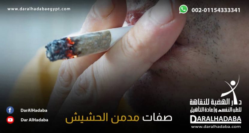 يد شخص بيده سيجارة نشتعله ويظهر جزء بني منها ويظهر شغفه مما يوضح صفات مدمن الحشيش