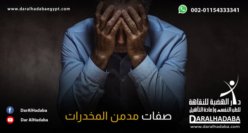 شخص جالش يرتدي قميص ازرق ويضع يديه على وجهه مكتئبا وهي أحد صفات مدمن المخدرات